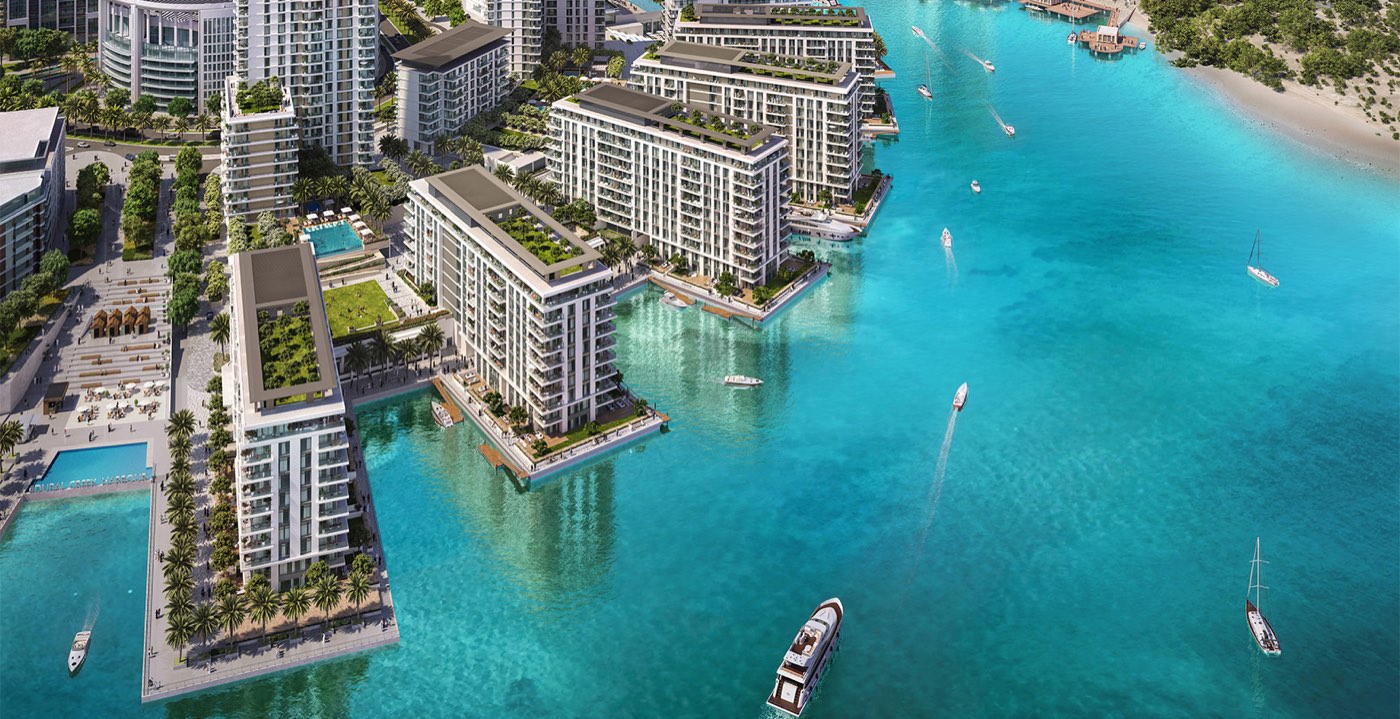 Aerial view of low waterfront residences and boats on the creek at Dubai Creek Harbour